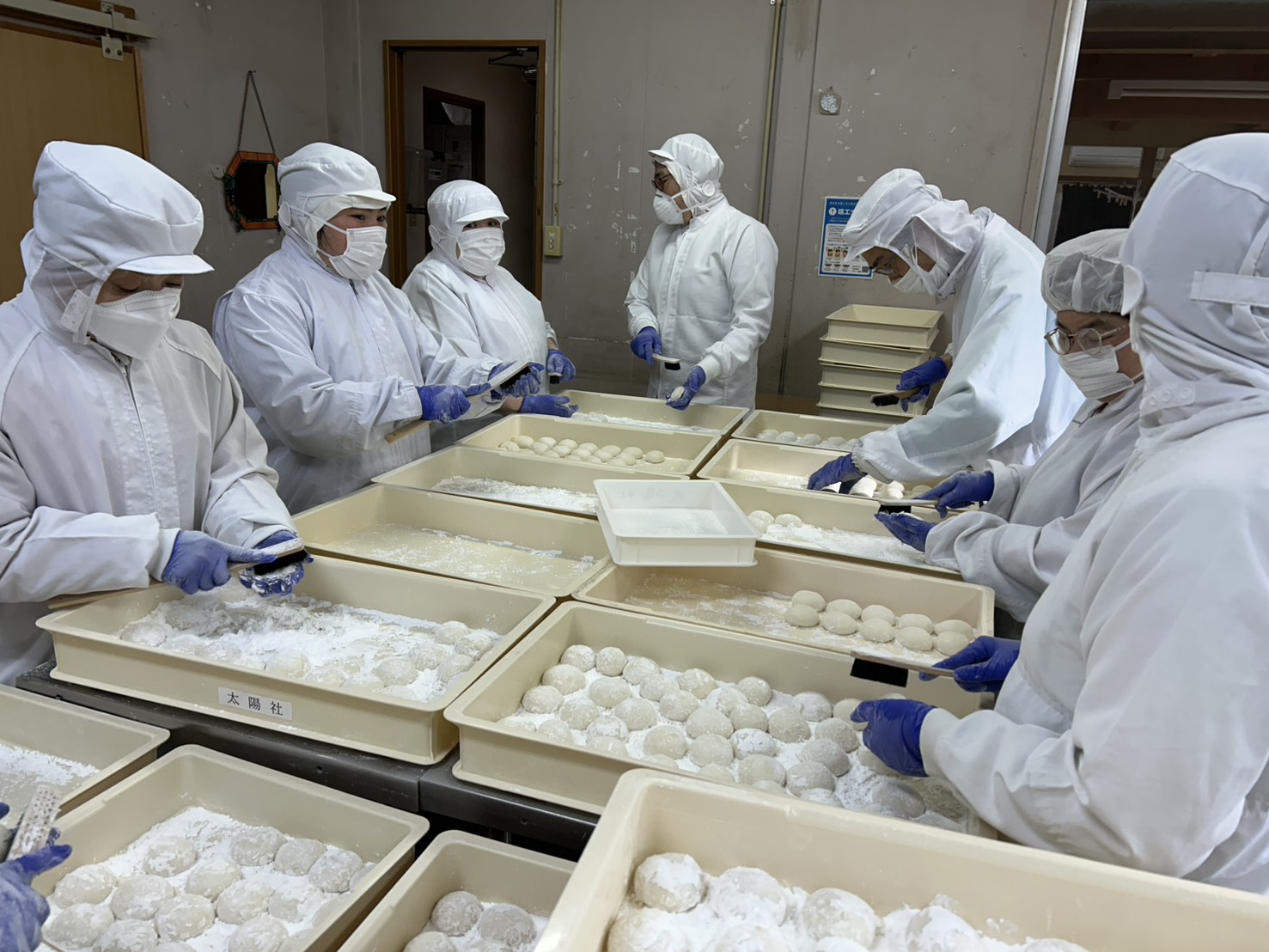 餅の粉払い作業